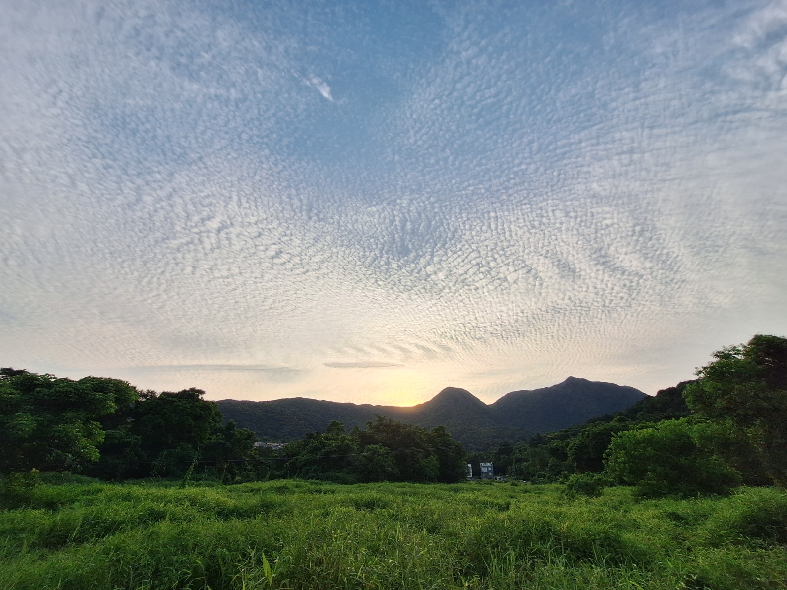 西貢農地黃昏時分的開闊山景，綠野與雲層交織