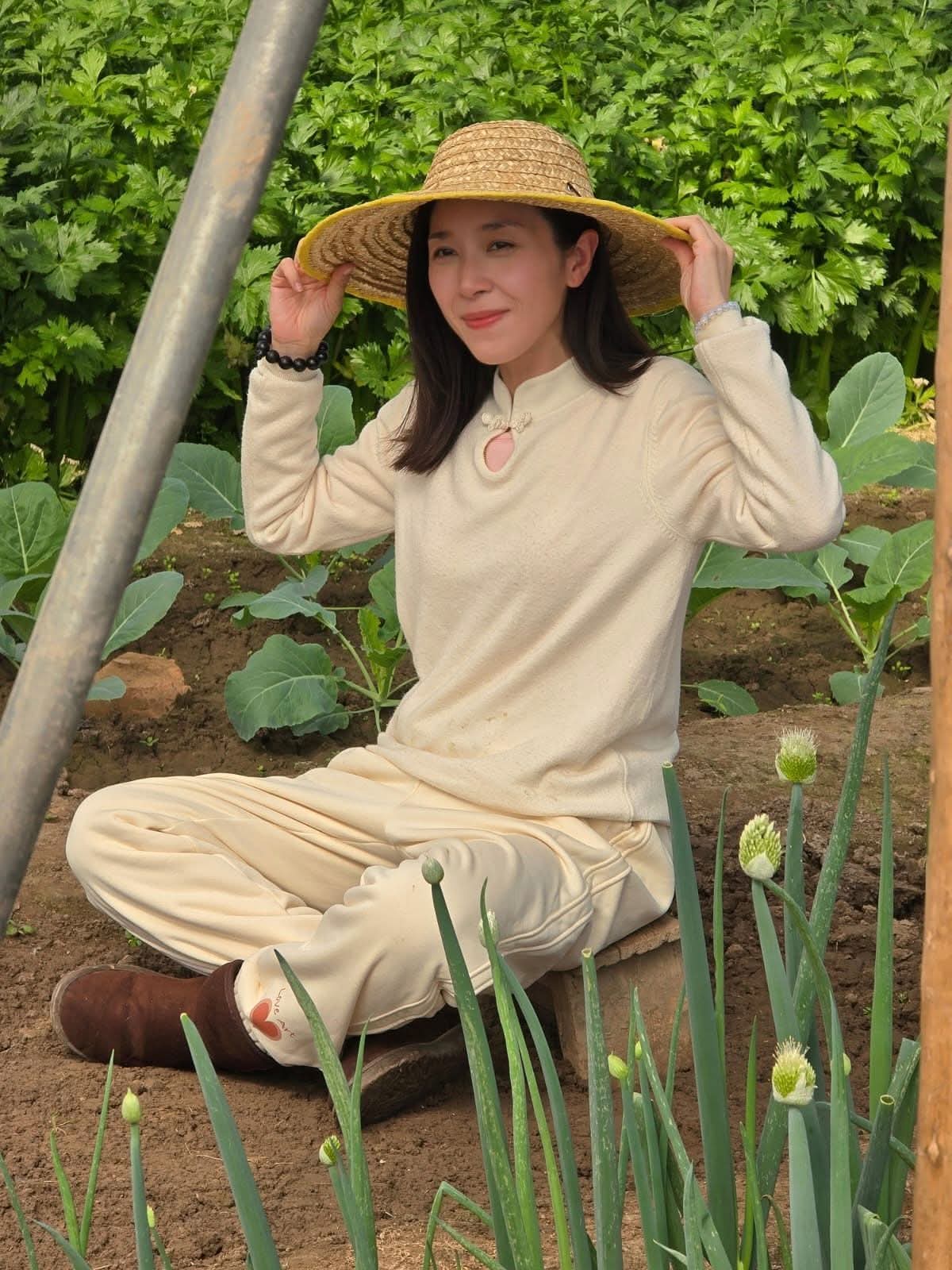 創辦人 Summer Yeung 戴着草帽坐在西貢農田中